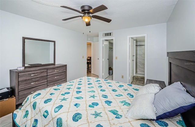 bedroom featuring connected bathroom, ceiling fan, a walk in closet, visible vents, and a closet