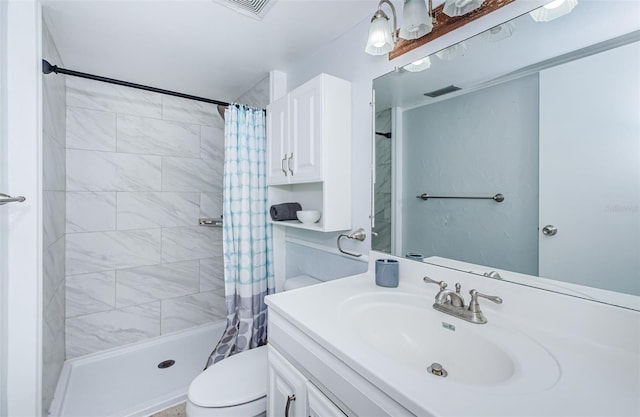 full bath featuring vanity, toilet, tiled shower, and visible vents