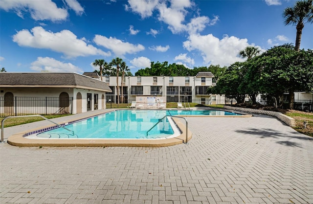 community pool featuring fence and a patio area