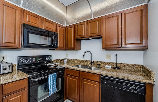kitchen featuring a sink, brown cabinetry, and black appliances