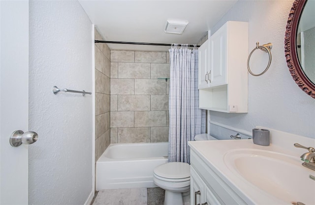 bathroom featuring vanity, a textured wall, toilet, and shower / tub combo
