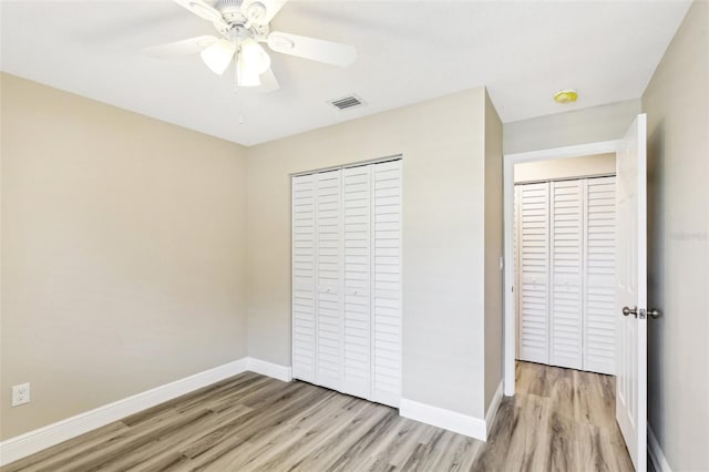 1203 16th Cir SE, Largo, FL 33771 - unfurnished bedroom with light wood finished floors, baseboards, a closet, and a ceiling fan