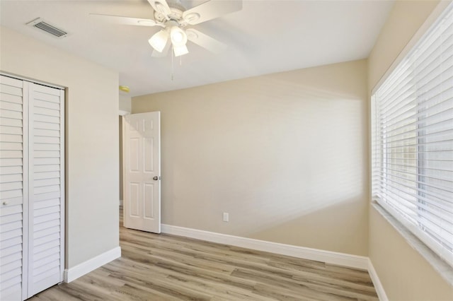 1203 16th Cir SE, Largo, FL 33771 - unfurnished bedroom featuring light wood-style flooring, baseboards, a closet, and ceiling fan