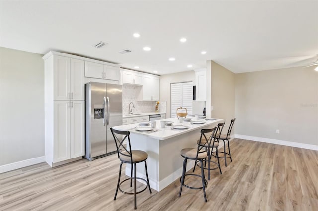 1203 16th Cir SE, Largo, FL 33771 - kitchen with stainless steel appliances, light wood-style floors, a breakfast bar area, light countertops, and baseboards