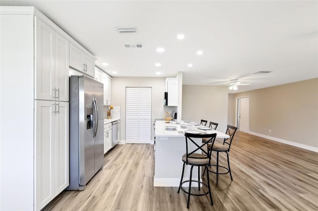 1203 16th Cir SE, Largo, FL 33771 - kitchen featuring appliances with stainless steel finishes, a kitchen breakfast bar, light countertops, light wood finished floors, and recessed lighting