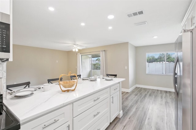 1203 16th Cir SE, Largo, FL 33771 - kitchen featuring stainless steel appliances, white cabinetry, light wood-style floors, baseboards, and recessed lighting