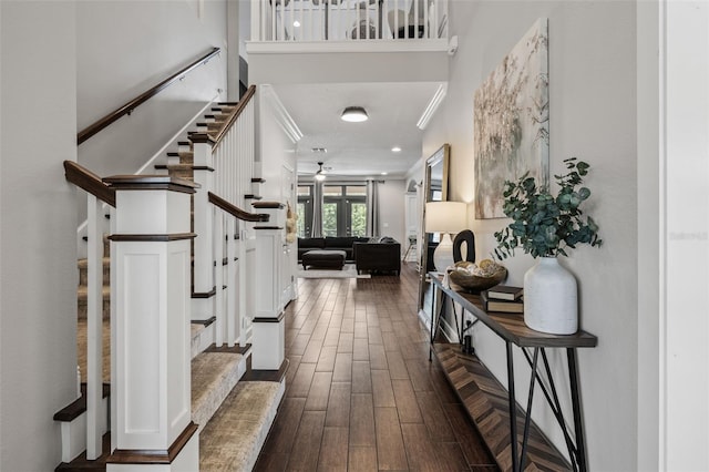 foyer entrance with stairs, dark wood-type flooring, and ceiling fan