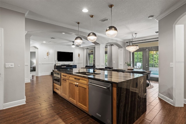 kitchen with wood finish floors, visible vents, ceiling fan, stainless steel dishwasher, and arched walkways