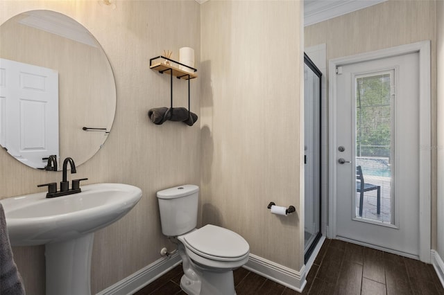 bathroom with baseboards, toilet, a shower stall, a sink, and wood finished floors