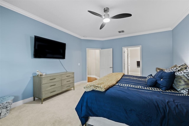 carpeted bedroom with crown molding, ensuite bathroom, a ceiling fan, visible vents, and baseboards