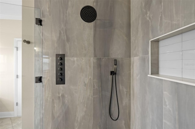 bathroom featuring tile patterned floors and a marble finish shower