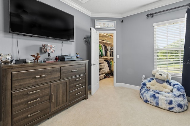 bedroom with a closet, ornamental molding, light carpet, a walk in closet, and baseboards