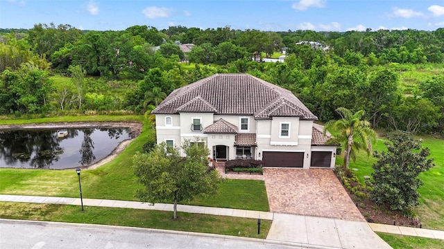view of front of house featuring a front yard, a tiled roof, a garage, stucco siding, and driveway