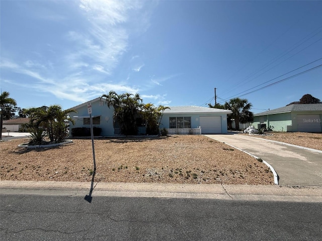 195 45th Ave, St Pete Beach, FL 33706 - view of front facade featuring concrete driveway, an attached garage, and stucco siding