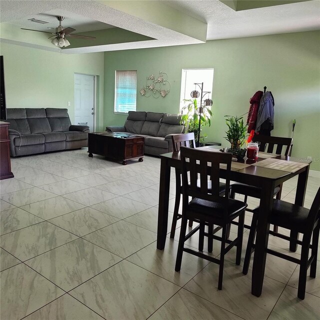 6690 54th Ave N, Saint Petersburg, FL 33709 - dining space featuring a textured ceiling, marble finish floor, a ceiling fan, and visible vents