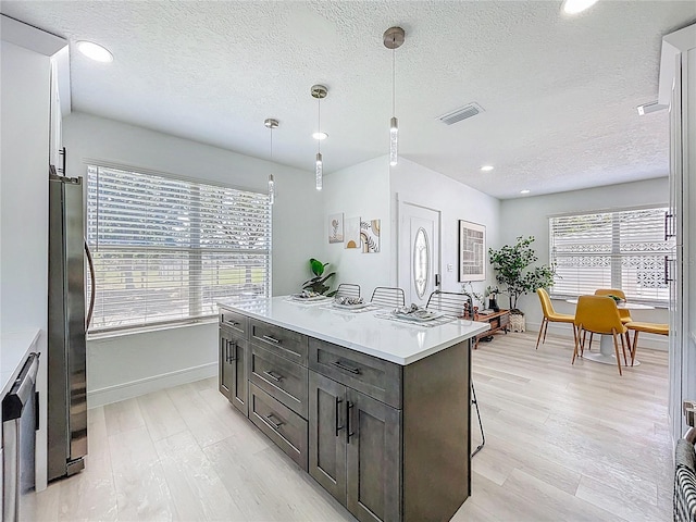 2711 W Cordelia St, Tampa, FL 33607 - kitchen featuring stainless steel appliances, visible vents, light wood-type flooring, and a textured ceiling