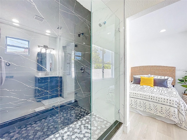 2711 W Cordelia St, Tampa, FL 33607 - bathroom featuring a wealth of natural light, a marble finish shower, and wood finished floors