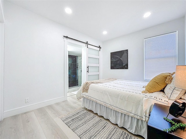 2711 W Cordelia St, Tampa, FL 33607 - bedroom with recessed lighting, a barn door, light wood-style flooring, and baseboards