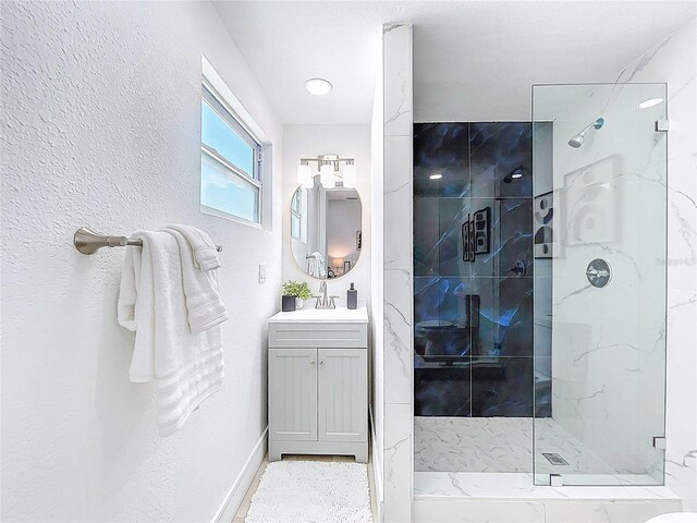 2711 W Cordelia St, Tampa, FL 33607 - bathroom featuring a marble finish shower, baseboards, and vanity