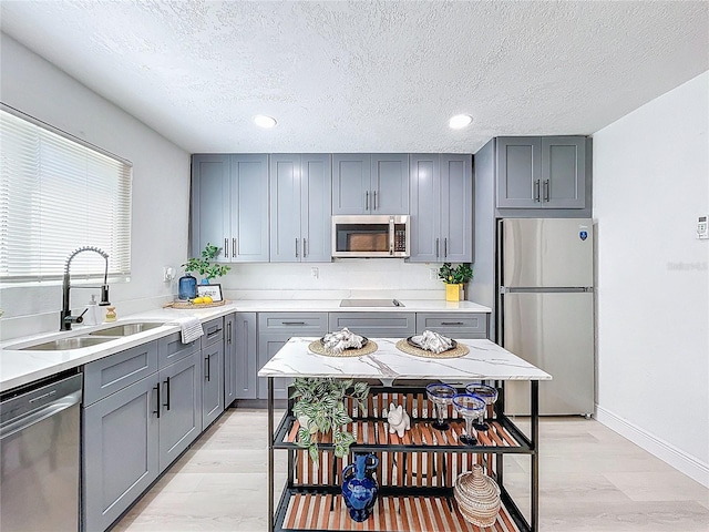 2711 W Cordelia St, Tampa, FL 33607 - kitchen featuring gray cabinetry, a sink, a textured ceiling, and stainless steel appliances