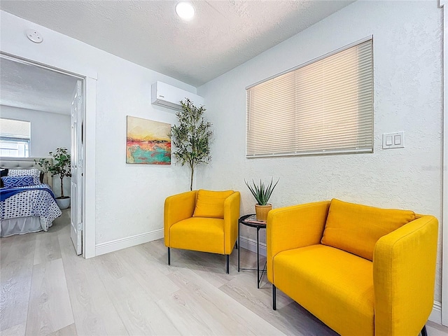 2711 W Cordelia St, Tampa, FL 33607 - sitting room with a wall mounted AC, baseboards, a textured ceiling, and wood finished floors