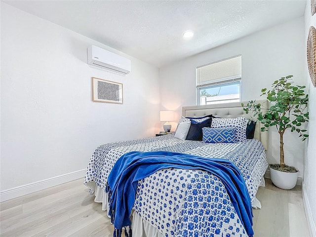 2711 W Cordelia St, Tampa, FL 33607 - bedroom featuring a wall mounted air conditioner, baseboards, a textured ceiling, and wood finished floors