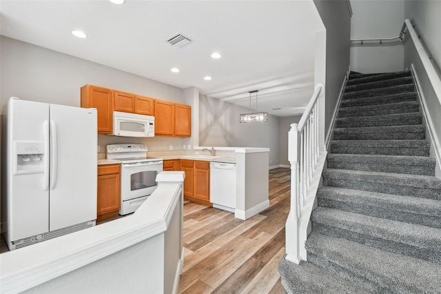 10407 Westpark Preserve Blvd, Tampa, FL 33625 - kitchen featuring white appliances, a sink, a peninsula, recessed lighting, and light wood-style floors