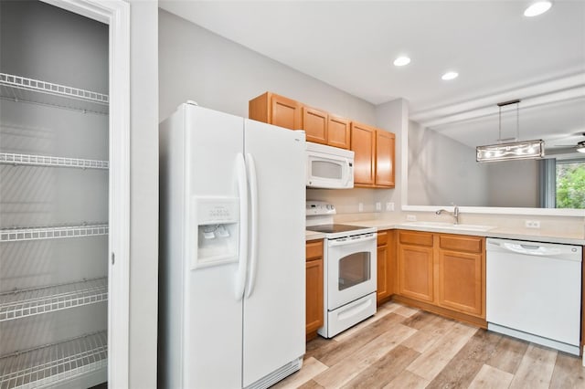 10407 Westpark Preserve Blvd, Tampa, FL 33625 - kitchen featuring white appliances, a sink, light countertops, light wood-style flooring, and recessed lighting