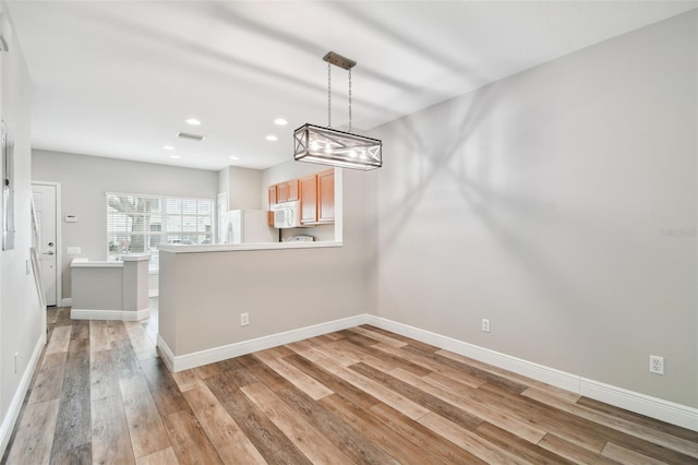 10407 Westpark Preserve Blvd, Tampa, FL 33625 - unfurnished dining area with light wood finished floors, baseboards, recessed lighting, and a chandelier