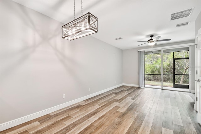 10407 Westpark Preserve Blvd, Tampa, FL 33625 - unfurnished room featuring ceiling fan, baseboards, light wood-style flooring, and a chandelier