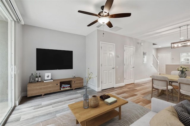 10407 Westpark Preserve Blvd, Tampa, FL 33625 - living area with a ceiling fan, light wood-type flooring, baseboards, and stairs