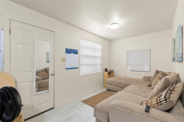 living area featuring marble finish floor and baseboards