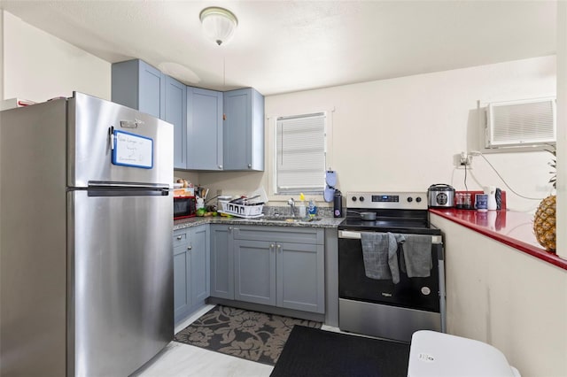 kitchen featuring blue cabinetry, stainless steel appliances, and an AC wall unit