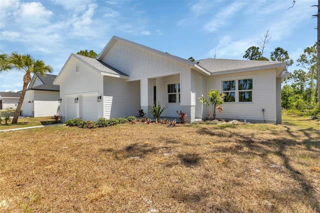 single story home featuring a shingled roof, a front yard, and a garage