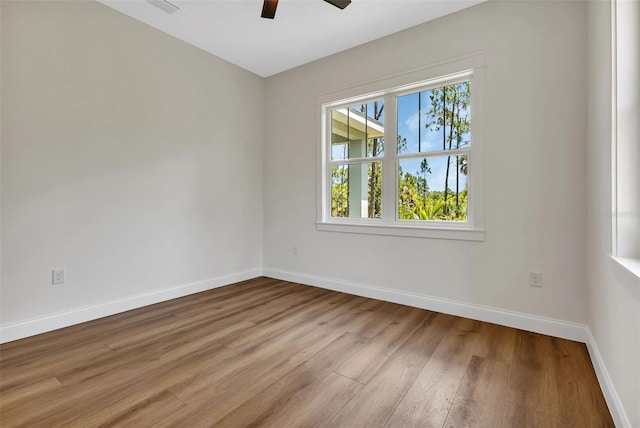 empty room featuring baseboards, a ceiling fan, and wood finished floors