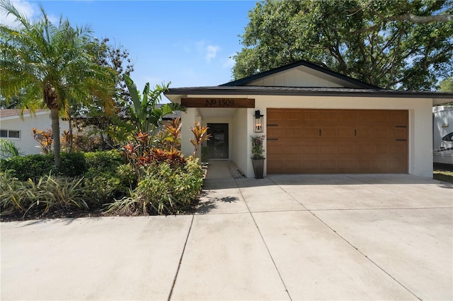 ranch-style home featuring concrete driveway, an attached garage, and stucco siding