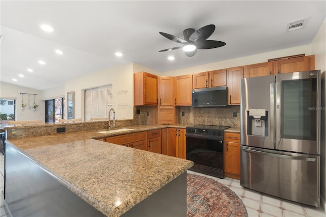 kitchen featuring stainless steel refrigerator with ice dispenser, visible vents, black electric range, a sink, and a peninsula