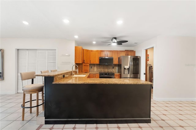 kitchen with a sink, a peninsula, electric stove, stainless steel fridge with ice dispenser, and a ceiling fan