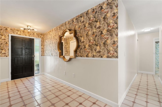 foyer featuring wainscoting and wallpapered walls