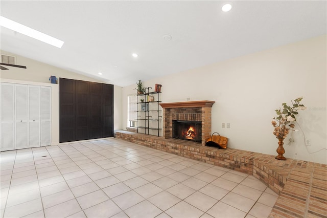 unfurnished living room with vaulted ceiling with skylight, a fireplace, recessed lighting, and light tile patterned flooring