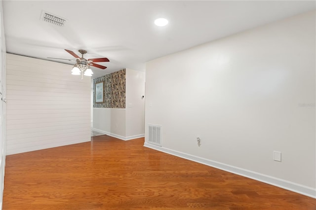 unfurnished room with visible vents, a ceiling fan, baseboards, and wood finished floors