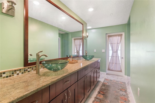 full bathroom with double vanity, baseboards, a sink, and marble finish floor