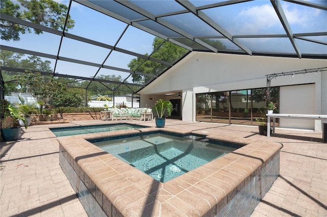 pool featuring a lanai, a ceiling fan, a patio, and an in ground hot tub