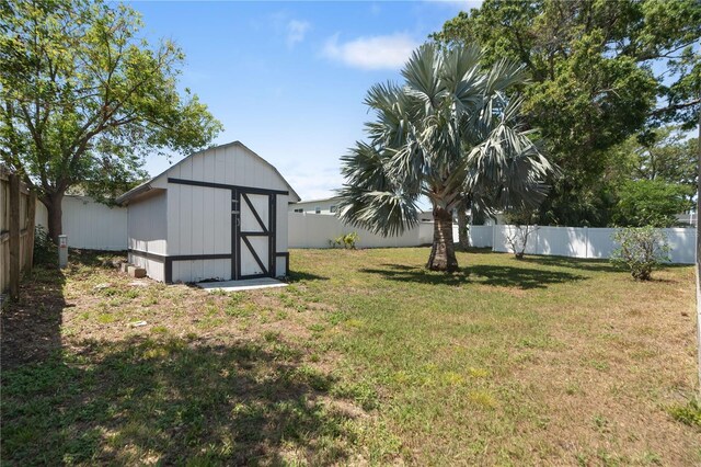 view of yard featuring a storage shed, an outdoor structure, and a fenced backyard