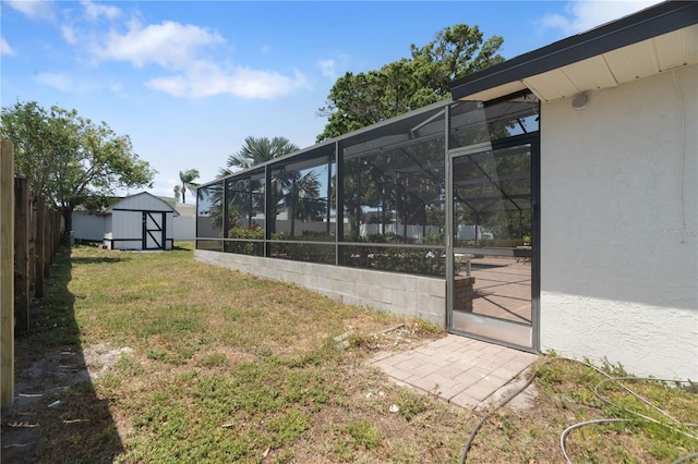 view of yard featuring an outdoor structure, a lanai, a shed, and fence