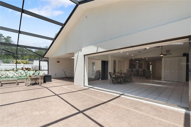 exterior space with an outdoor living space, a ceiling fan, visible vents, glass enclosure, and outdoor dining space