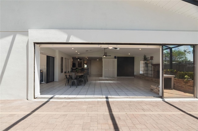 view of patio with a ceiling fan, outdoor dining area, and a garage