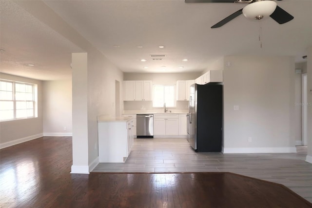 kitchen featuring light wood-type flooring, baseboards, a ceiling fan, visible vents, and stainless steel appliances