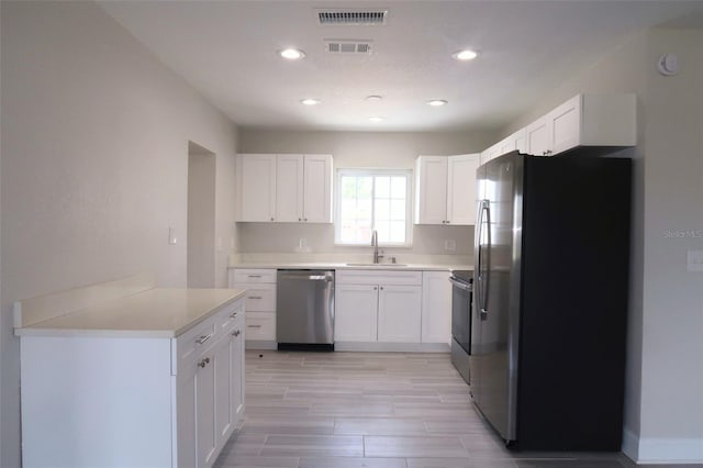 kitchen featuring white cabinetry, visible vents, appliances with stainless steel finishes, light countertops, and a sink