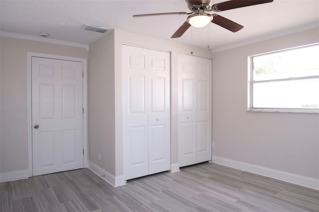 unfurnished bedroom featuring wood finished floors, baseboards, and visible vents